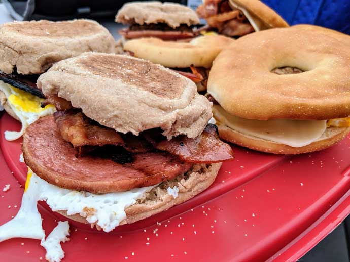 Tray of Breakfast Sandwiches with English Muffins and Bagels, Pork Roll, Eggs, and Bacon at a Tailgate