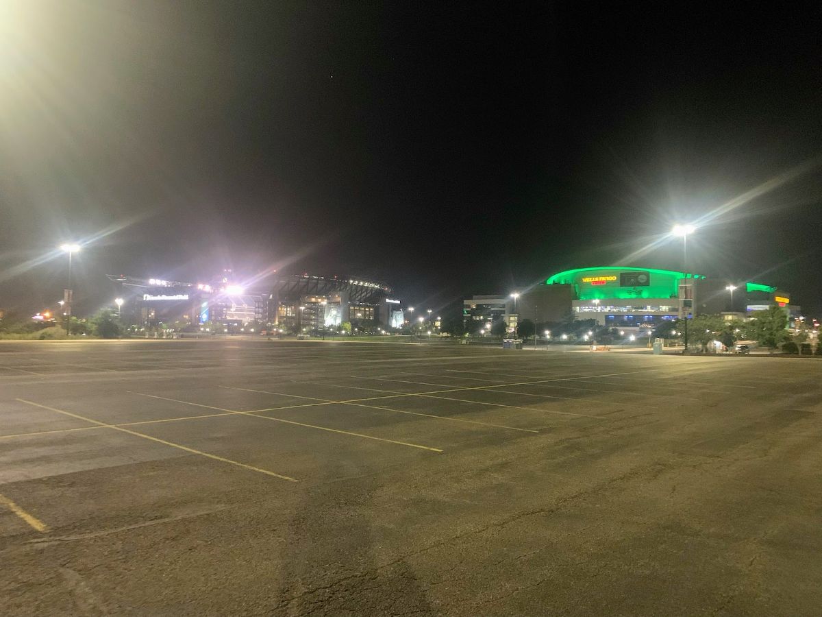 Reserving parking spaces for Eagles tailgating at 5 a.m. - Darkness surrounds Wells Fargo Center lit up in green for the birds.