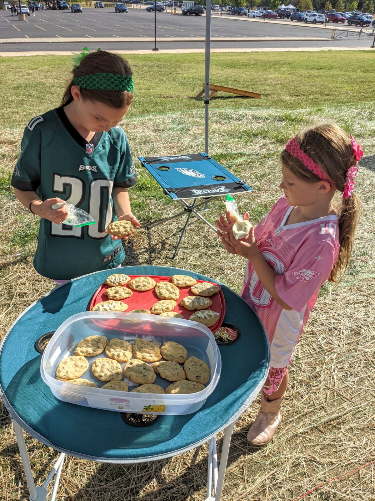 Two sisters decorating cookies on Philadelphia Eagles Tailgating Tables