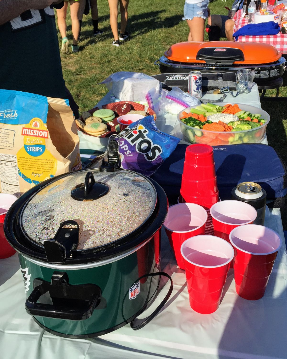Crockpot on Tailgating Table with cups and snacks
